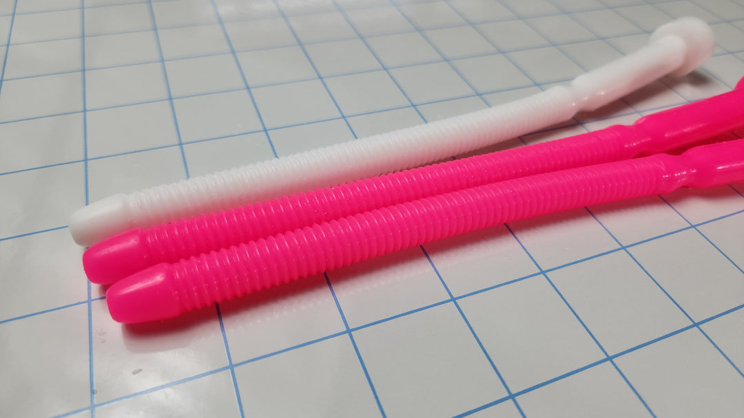 Two hot pink and one white SSND-THREADED13 silicone urethral sounds resting on a blue grid background, featuring an 8.3-inch insertable length, threaded shaft, and retention valley.