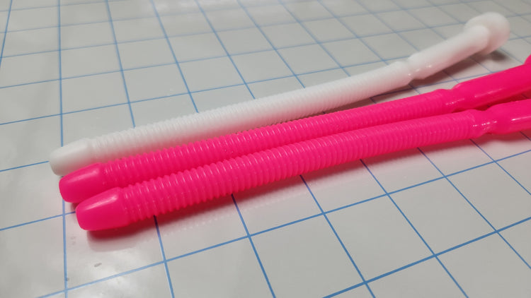 Two hot pink and one white SSND-THREADED13 silicone urethral sounds resting on a blue grid background, featuring an 8.3-inch insertable length, threaded shaft, and retention valley.