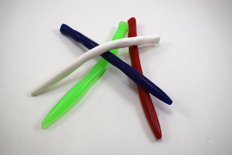A stack of four colorful tri-sided ripple silicone sounds in white, dark blue, green, and red on a plain background.