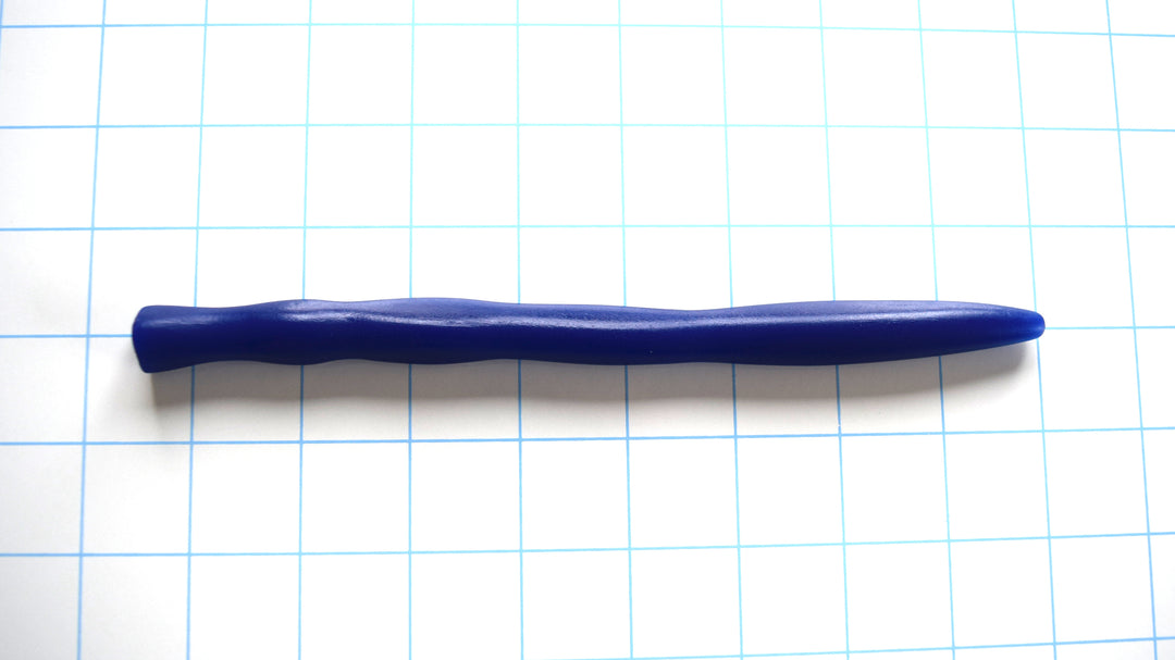 Blue silicone tri-sided ripple sound with smooth contoured ridges and a tapered base on a grid background.