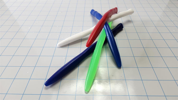 Four colourful (red, white, dark blue, green) flexible silicone SSND Tri-Sided RIPPLE urethral sounds, 8 inches long, clustered on a white grid background showing unique triangular ripple geometry.