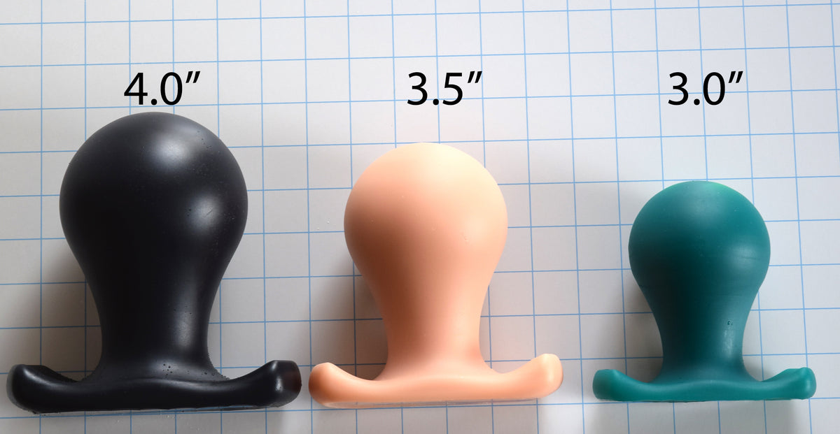 Side-by-side view of The Orb spherical silicone plug showing its bulb-style head, tapered neck, and contoured oval base flange in various colors.