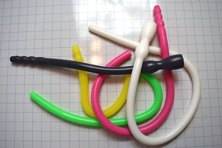 Assorted 0.825-inch diameter silicone colon tubes in various colors and designs, shown on a grid background