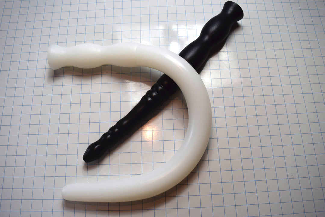 Assorted 2-inch diameter silicone colon tubes in various colors and designs, shown on a grid background