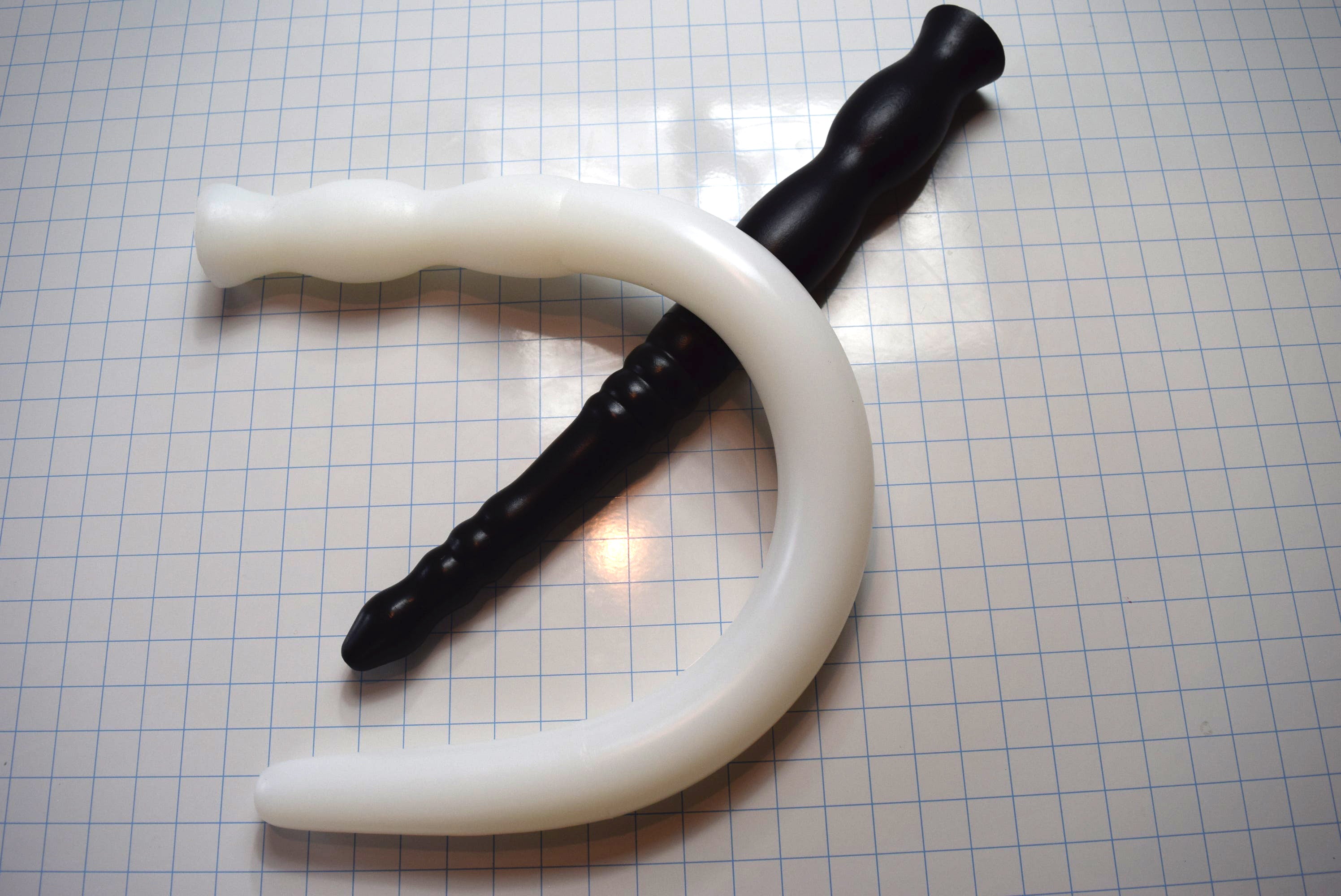 Assorted 2-inch diameter silicone colon tubes in various colors and designs, shown on a grid background