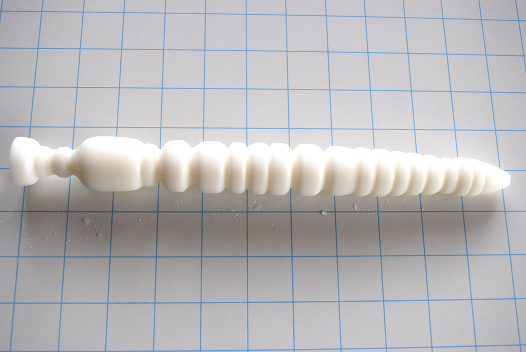 Vibe 11-inch white silicone enema nozzle featuring 18 sensory ribs and valleys, tapered design, and a comfortable retention flange on a white grid background